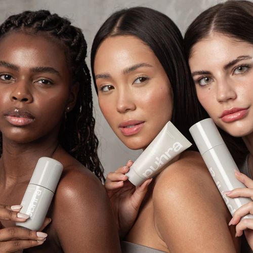 Três mulheres com peles diferentes segurando produtos da linha Puhra